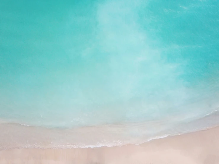 an overhead view of a beach with blue water