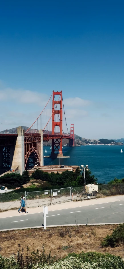 a couple of cars on the street by the golden gate bridge