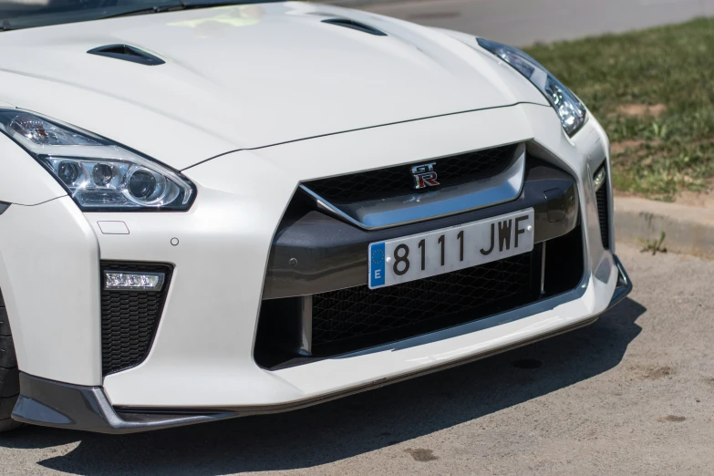 the front of a white sports car on the street