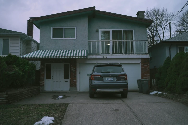 a car parked in front of a grey home