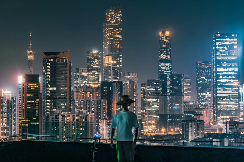 two people standing by the water looking at a city