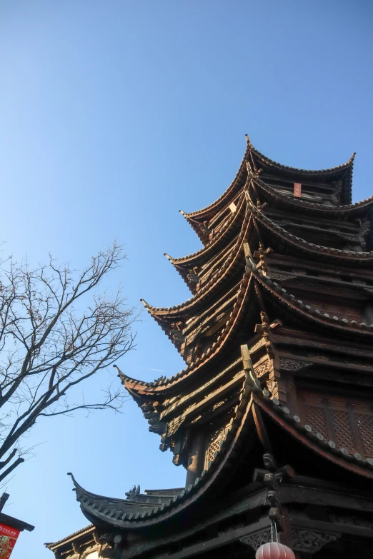 a tall tower with pagodas above it with trees around