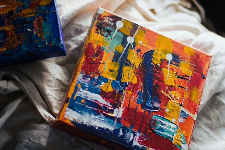 two colorful paintings are sitting on the bed