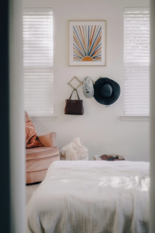 a hat is hanging on the wall by a bed