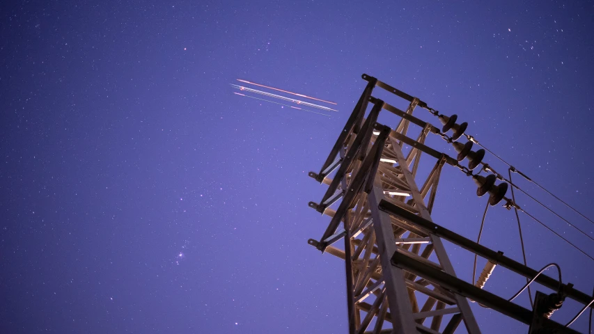 an airplane is flying over a tall building with the stars above