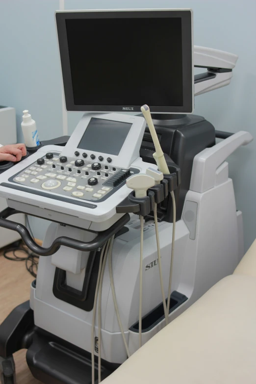 a large electronic machine sits on a medical exam table