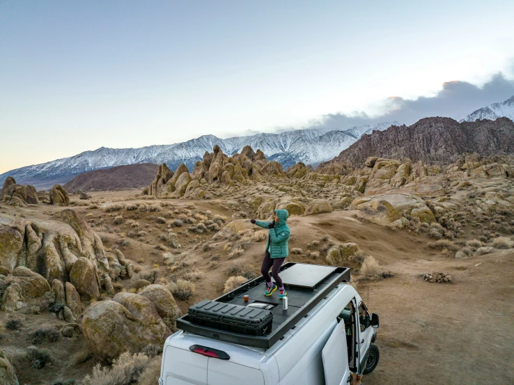 a person standing on top of a camper van