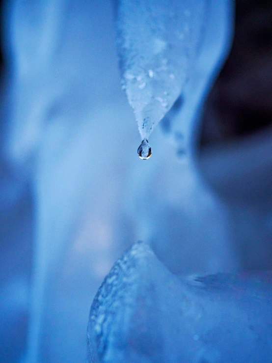 a drop of water hangs from a fountain