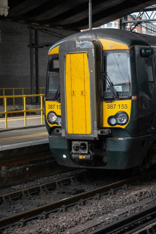 a yellow and black train engine pulling into a station