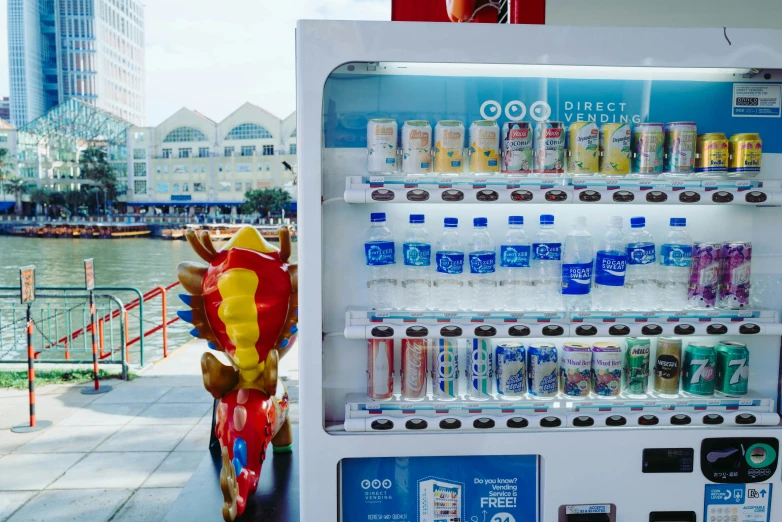 a vending machine for soda in front of the water