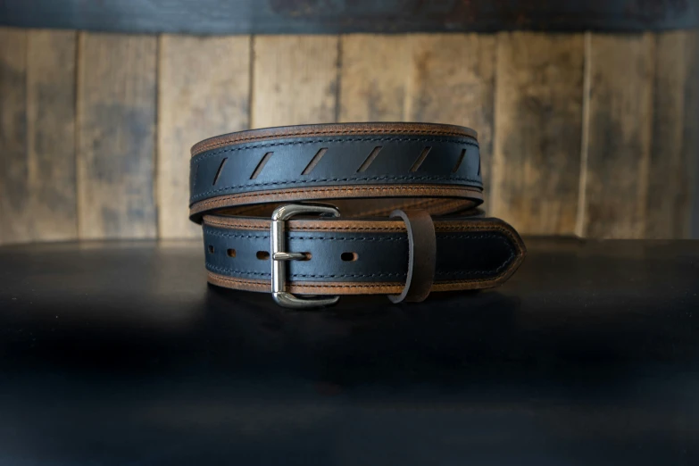two belts stacked together on a black table