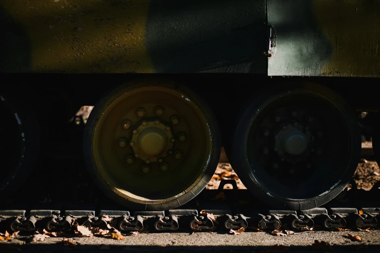 the wheel of a train that is near some leaves