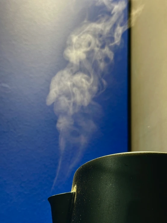 smoke is coming out of a mug in front of a wall