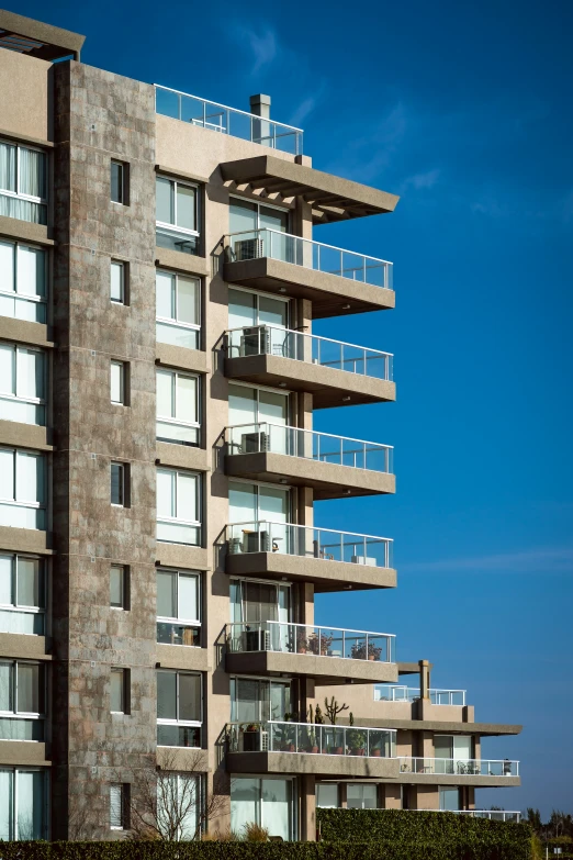 an apartment building with balconies and a clock on the side