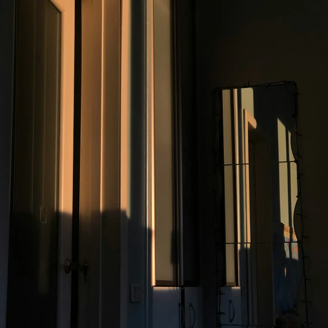 a hallway in a home with sun reflecting off the windows