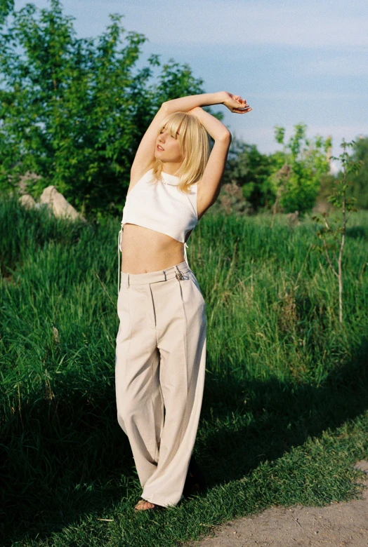 a woman with blonde hair and wearing wide slacks