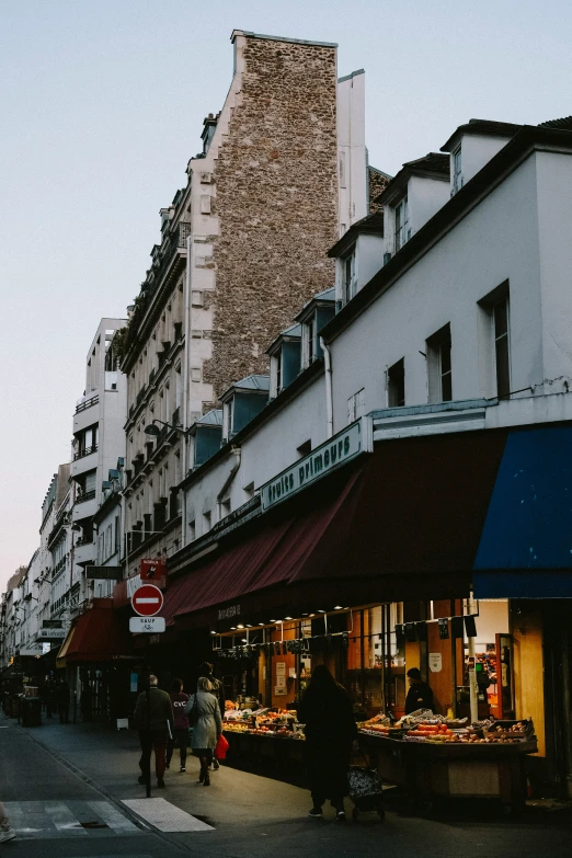 people walk by in an empty street lined with businesses