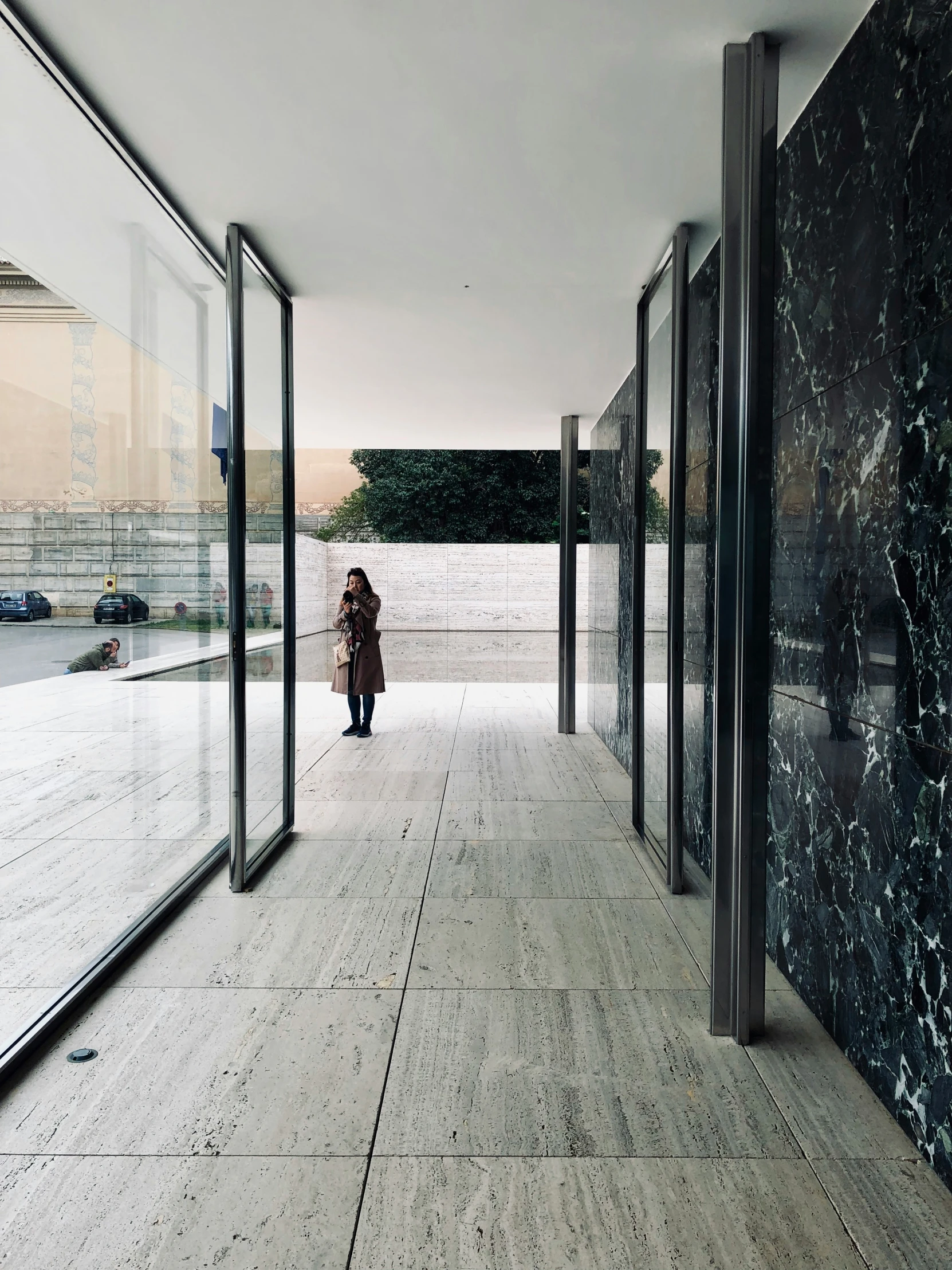 a person walking down a walkway in a room with mirrored walls