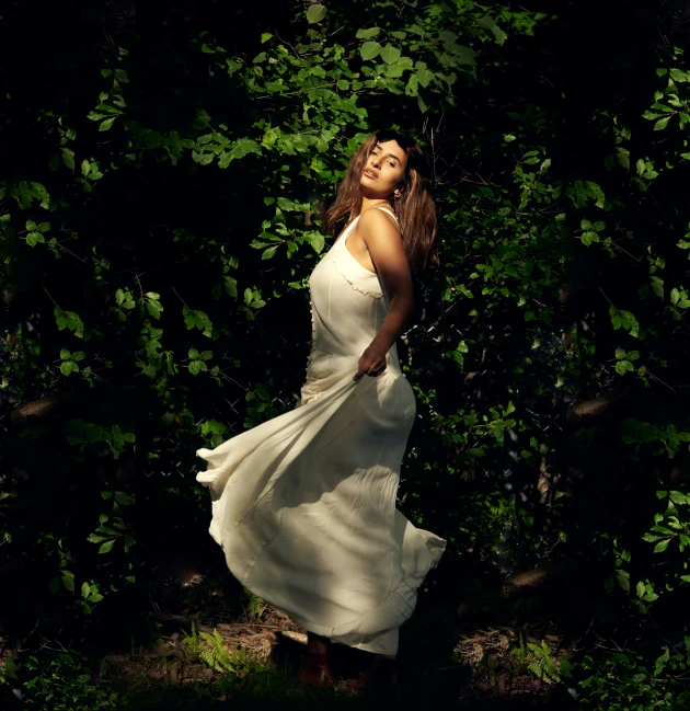 a girl is posing in front of some trees