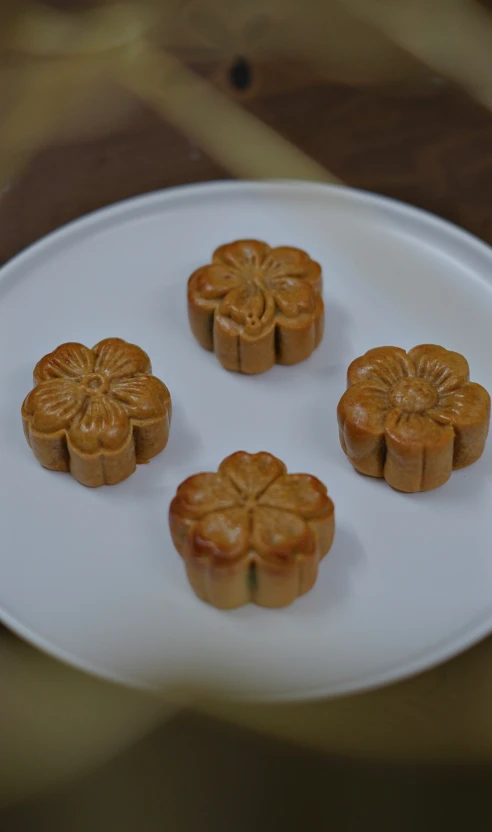 a white plate with four chinese food on it