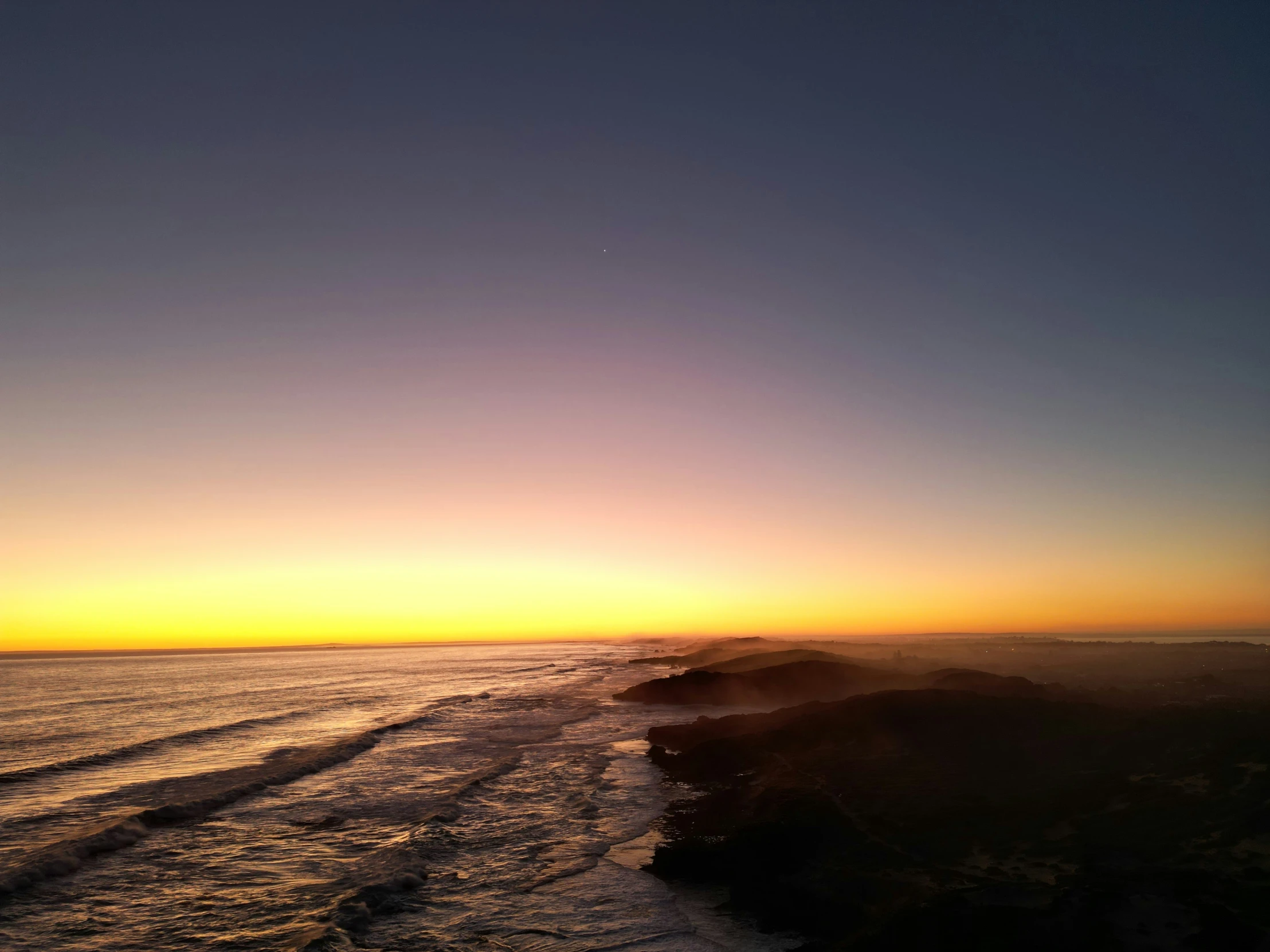 sunset with waves in the water on a beach