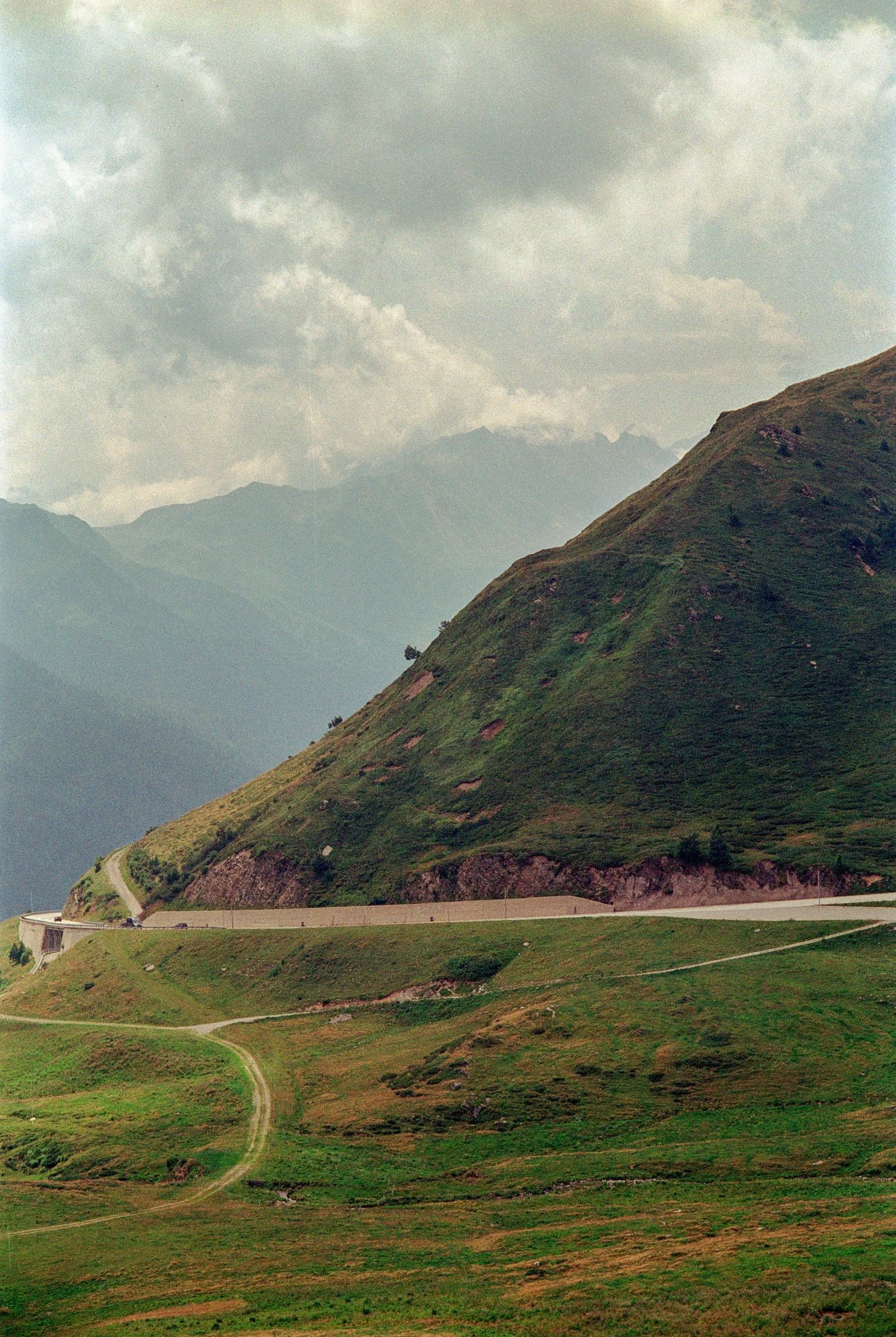 a very large mountain with a green grassy field in front