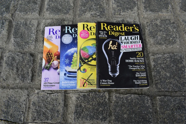 three magazines lying on the ground, all lined up