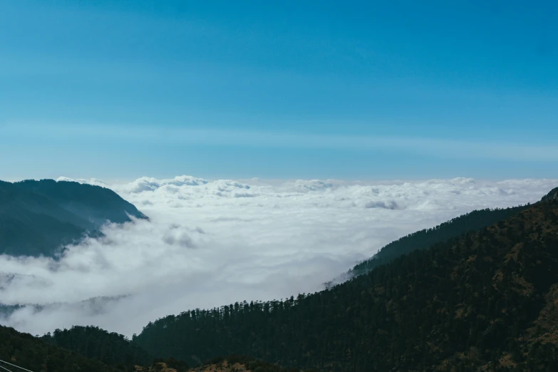 a mountain area is seen with clouds hovering