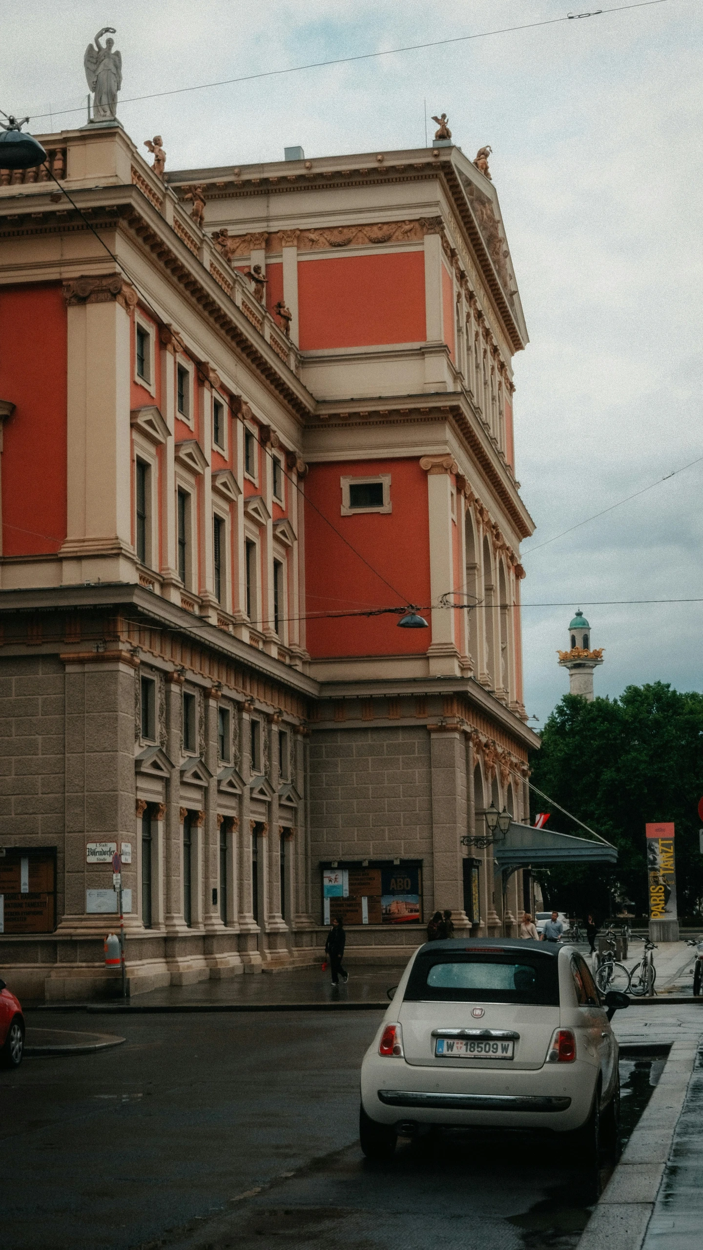 cars sit parked in front of buildings in the day