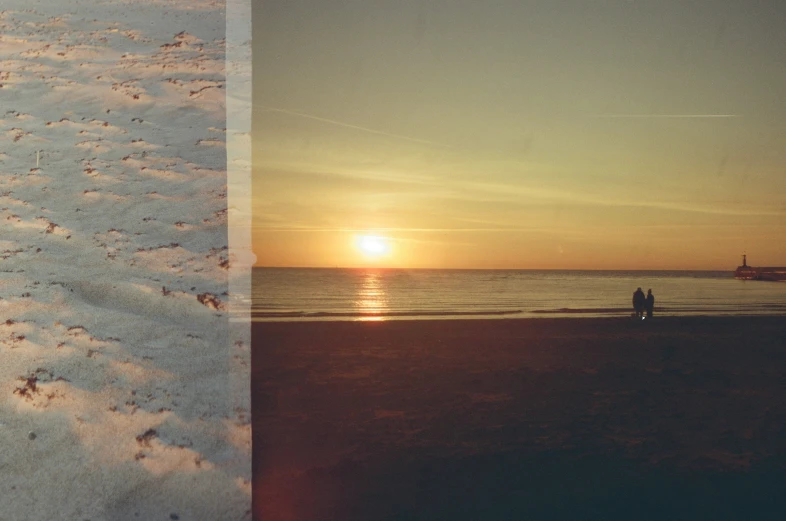 two people walking on a beach at sunset