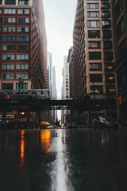 people crossing a walkway over water next to tall buildings