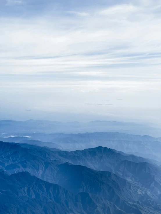 a large plane flying over a mountain with clouds