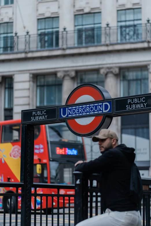 a man sitting on a bench underneath a sign