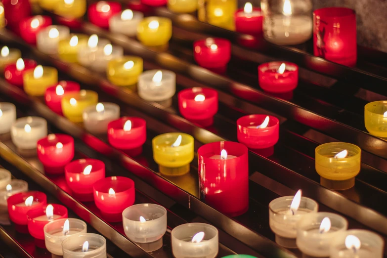 a collection of lit candles on a shelf