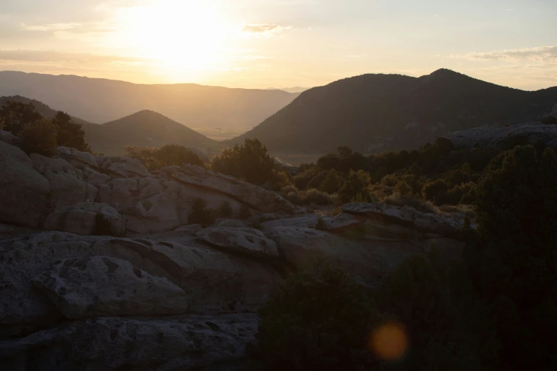 the sun shining over mountains and rocks