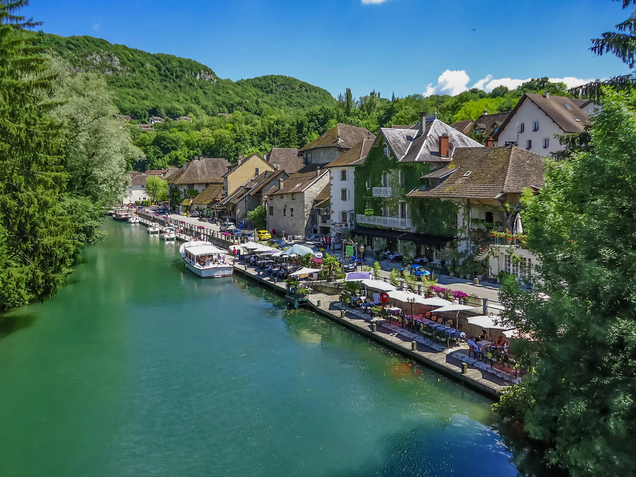 a river with several umbrellas next to a small town