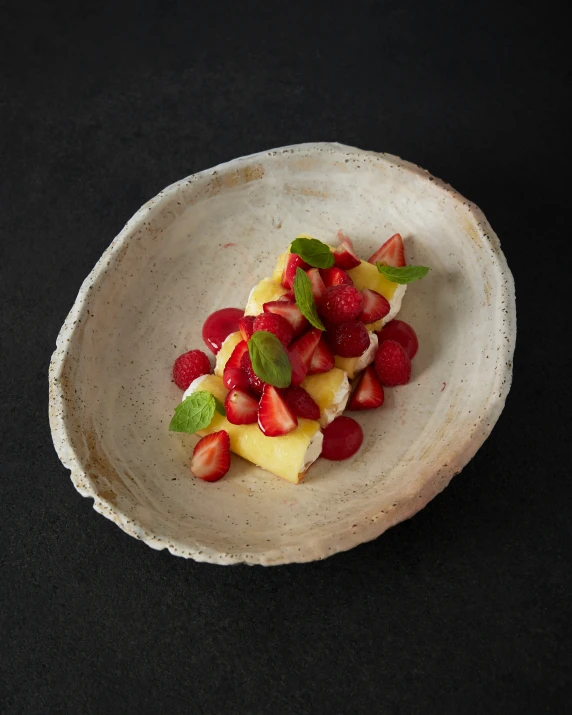 a fruit salad sits on a small, empty bowl