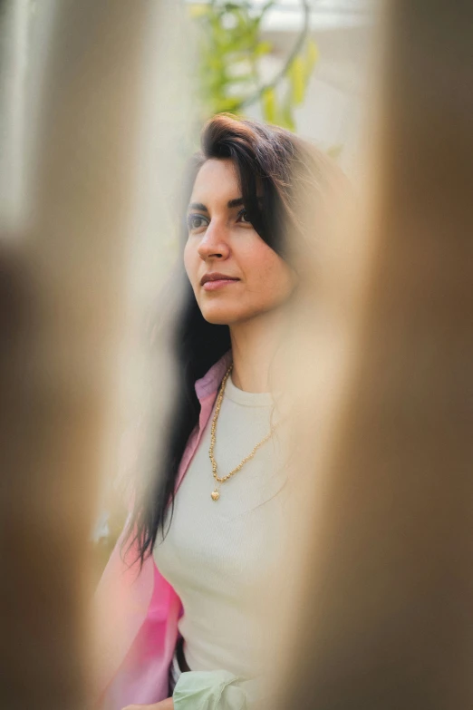 a woman stands in front of another woman and looks through a mirror