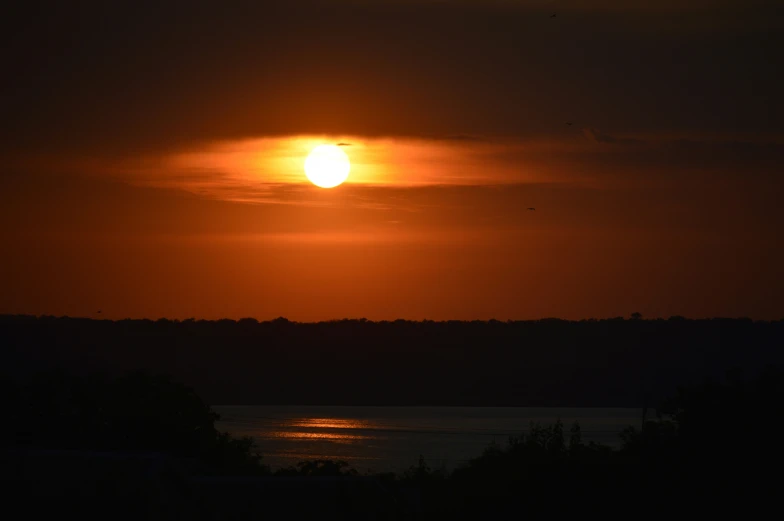 a small airplane is flying in the sky at sunset