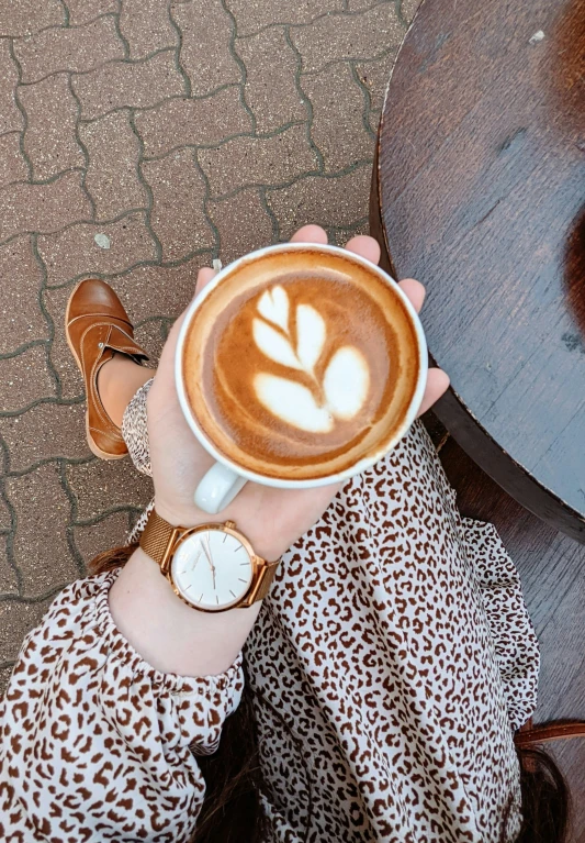 a cup of  chocolate has a leaf design on it