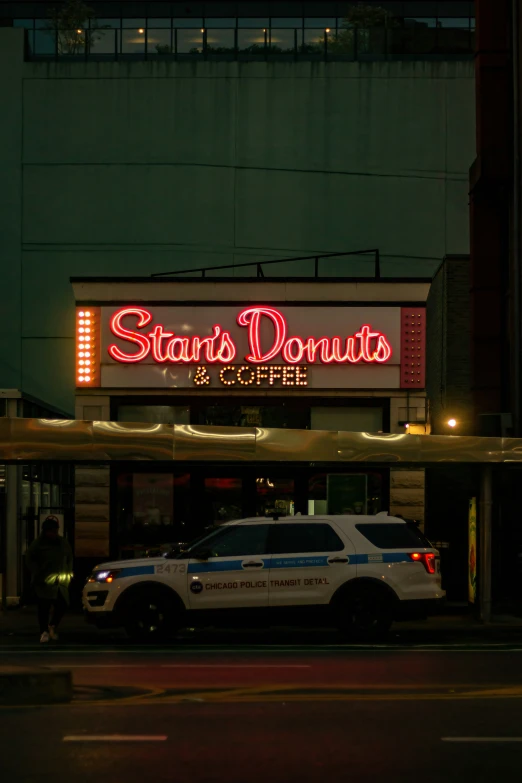 a police car parked in front of a diner