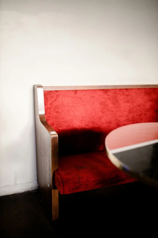 a corner sitting area with red velvet furniture