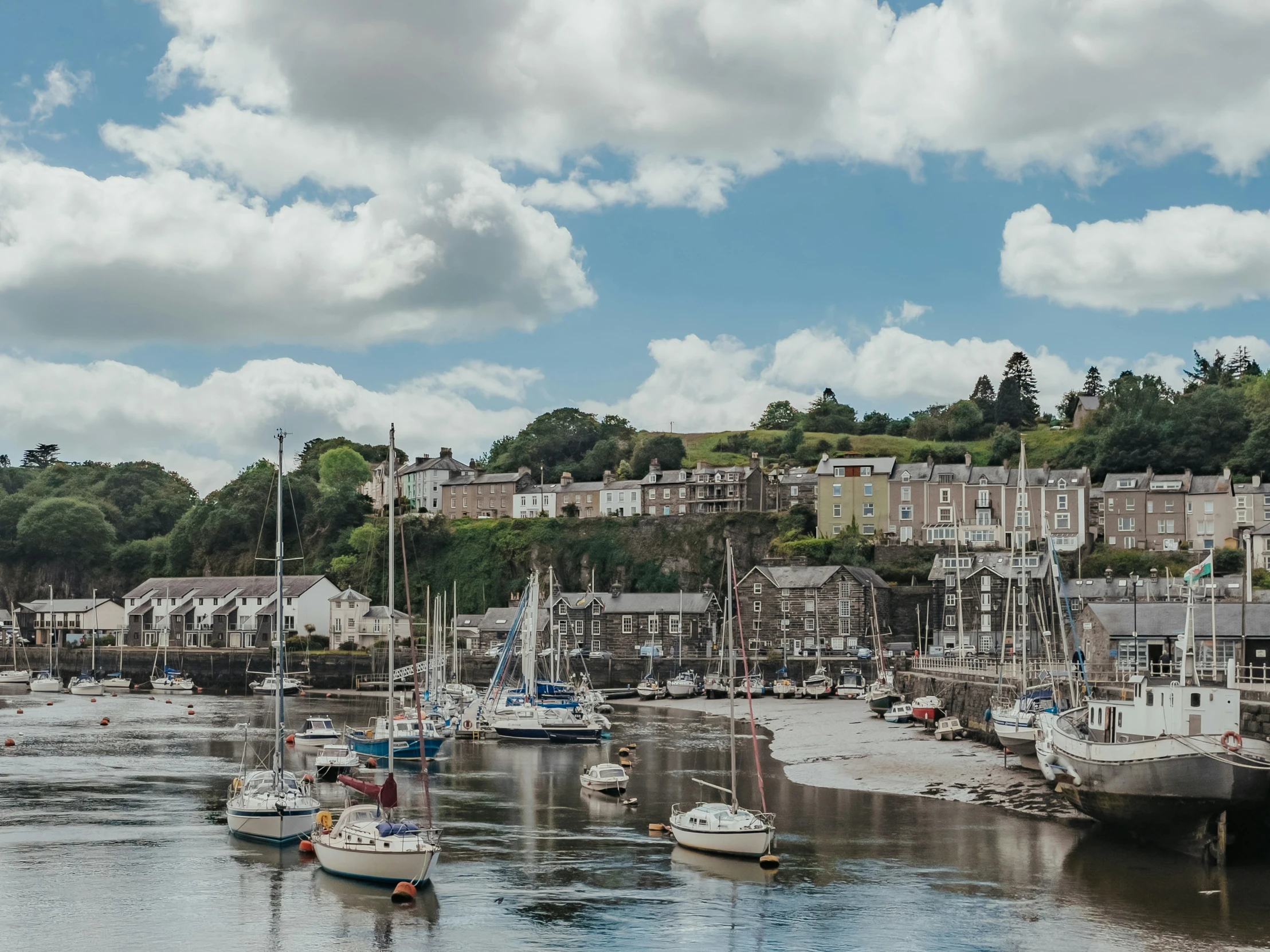 several boats are docked on a river by several houses