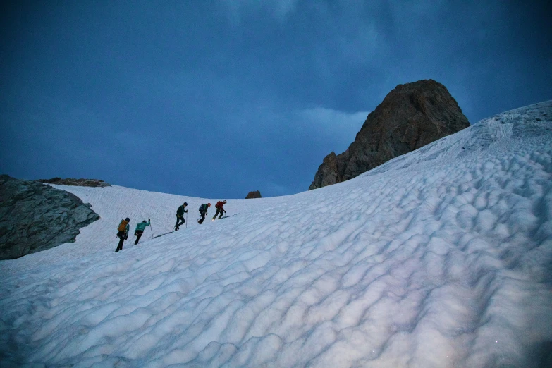 skiers skiing on the side of a snowy mountain