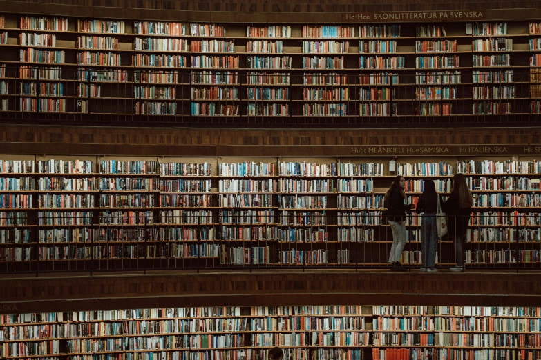 a long room full of book cases with many people