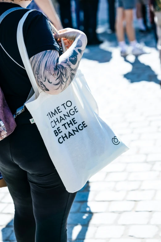 a woman carrying a large white tote bag