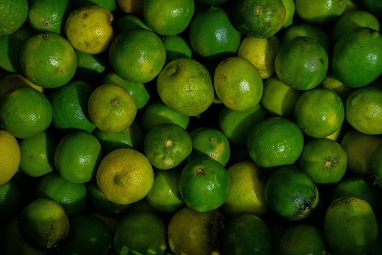 a large pile of green limes sitting on top of a table