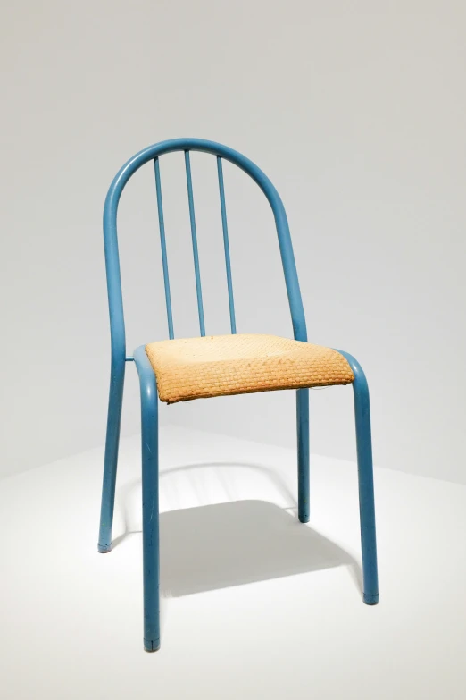 the blue chair with a wooden seat is on a white surface