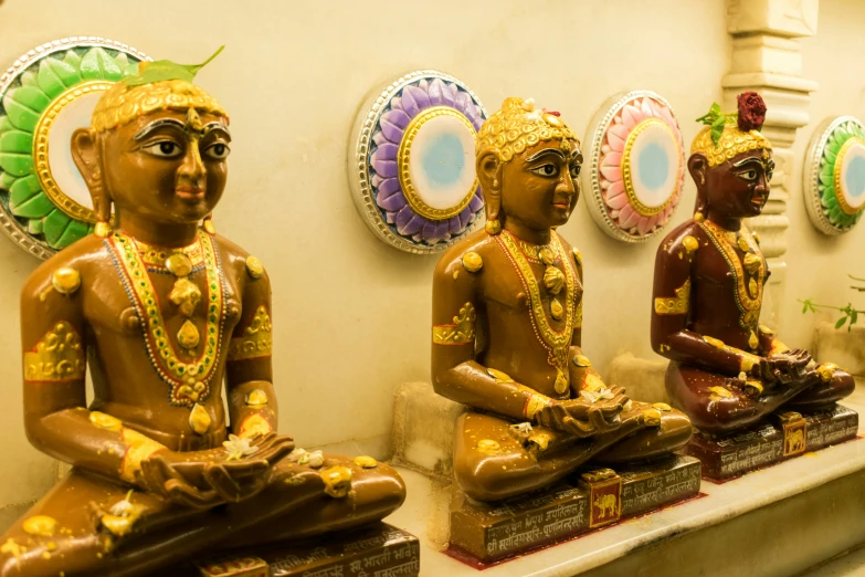 statues are set up against a wall in the shape of buddhas