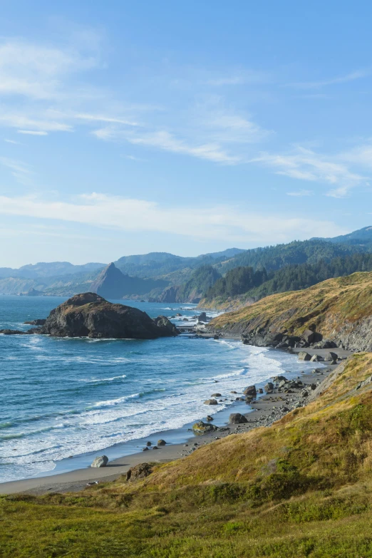 an ocean view with hills and blue skies